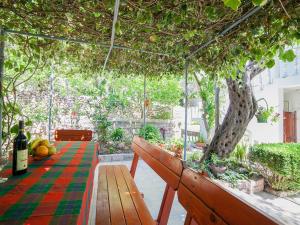 a glass greenhouse with a table and a tree at Rooms Garden in Petrovac na Moru