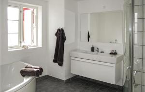 a white bathroom with a tub and a sink at Three-Bedroom Holiday Home In Skagen in Skagen