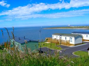 a view of a house and the ocean at 8 person static caravan in Heysham