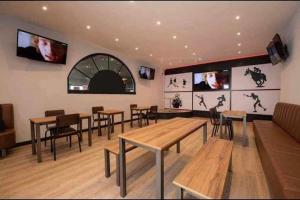 a restaurant with tables and chairs and televisions on the wall at 8 person static caravan in Heysham