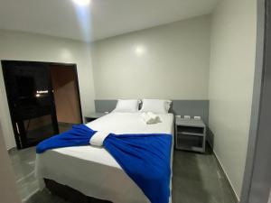 a bedroom with a bed with a blue blanket on it at Flat no coração de brasília in Brasilia