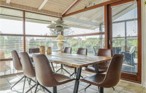 uma sala de jantar com uma mesa de madeira e cadeiras em Gorgeous Home In Blokhus With Wifi em Blokhus