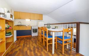 una cucina con tavolo, sedie e frigorifero di 2 Bedroom Cozy Home In Porticcio a Porticcio