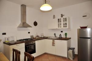 a kitchen with white cabinets and a stainless steel refrigerator at La Casa sull'Archetto in Corciano