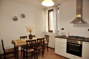 cocina y comedor con mesa y sillas en La Casa sull'Archetto, en Corciano