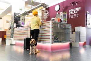 uma mulher com um cão em pé em frente a uma loja em Industriepalast Berlin em Berlim