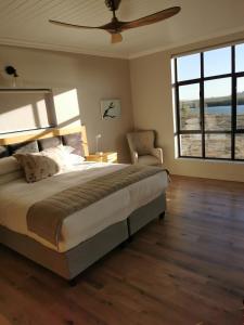 um quarto com uma cama grande e uma ventoinha de tecto em Lermitage Game Lodge - Solar Power em Velddrif