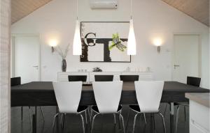 a dining room with a black table and white chairs at 4 Bedroom Pet Friendly Home In Lkken in Løkken