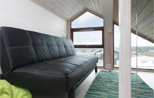 un sofá de cuero negro en una habitación con una gran ventana en 4 Bedroom Pet Friendly Home In Lkken, en Løkken