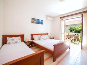 a bedroom with two beds and a balcony at Rooms Garden in Petrovac na Moru