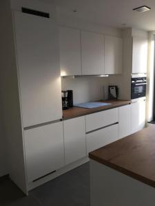 a kitchen with white cabinets and a counter top at Leuk overnachten in hartje Laarne, dicht bij Gent! in Laarne