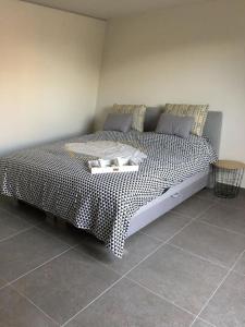 1 cama con edredón blanco y negro en una habitación en Leuk overnachten in hartje Laarne, dicht bij Gent! en Laarne