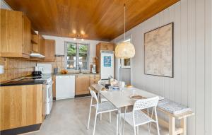 kuchnia ze stołem i krzesłami w kuchni w obiekcie Beautiful Home In Hejls With House Sea View w mieście Hejls