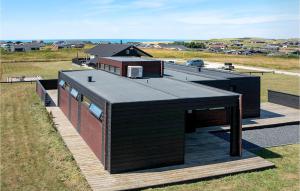 a house with a black roof on a deck at Three-Bedroom Holiday Home In Lokken in Løkken +23 photos