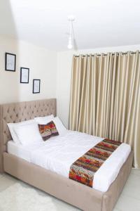 una camera da letto con un letto coperto di The Homey Haven a Eldoret