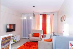 een woonkamer met een stoel en een televisie bij The Homey Haven in Eldoret