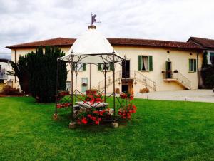 a church with a gazebo with flowers in a yard at Il Torchio - Guest House Lago Maggiore in Dormelletto