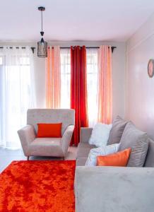 sala de estar con sofá y silla en The Homey Haven, en Eldoret