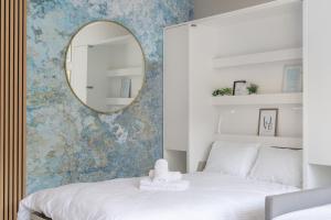 a bedroom with a white bed and a mirror at Blue Morpho Piątkowo Apartment in Poznań