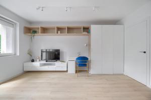a white kitchen with a blue chair in a room at Blue Morpho Piątkowo Apartment in Poznań