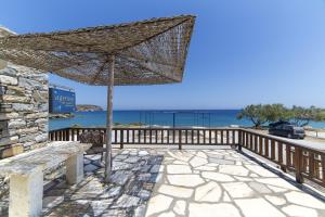 eine Terrasse mit Bank und Sonnenschirm in der Unterkunft Agerino in Moutsoúna