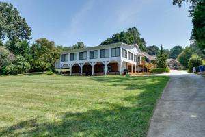 a large house on a grassy hill with a driveway at Spacious Lake Norman Retreat with Private Dock! in Sherrills Ford