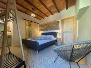 a bedroom with a bed and a chair in it at Castell de l'Aguda in Torá de Rulbregos