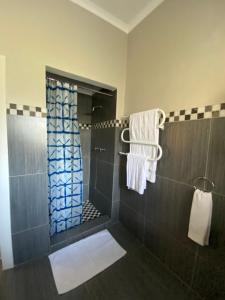a bathroom with a shower with a glass door at Vredelust Cottage in Bellville