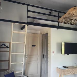 Zimmer mit einem Hochbett, einem Schreibtisch und einem TV in der Unterkunft À l'aube du sacré coeur in La Plaine des Palmistes