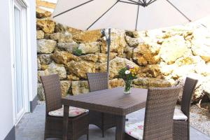 a table with a vase of flowers and an umbrella at Wunderwelt Betzenstein familiär-ländlich-modern in Betzenstein