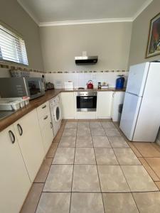 a kitchen with white appliances and a white refrigerator at Vredelust Cottage in Bellville