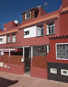 un bâtiment rouge avec une porte devant lui dans l'établissement Kiki vivienda Bed & breakfast, à San Isidro