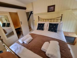 a bedroom with a large bed with white sheets and pillows at Smugglers Cottage in Barton on Sea