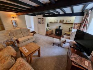 ein Wohnzimmer mit einem Sofa und einem Kamin in der Unterkunft Smugglers Cottage in Barton on Sea