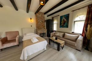 a living room with a bed and a couch at Antique Manastir Boutique Hotel in Edremit