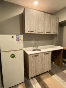 a kitchen with a white refrigerator and a sink at Vera Suit in Istanbul