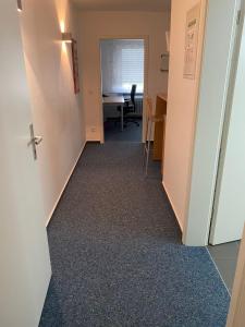 a hallway with a desk and a table in a room at AWM Korntal in Korntal-Münchingen