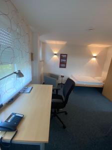 a room with a desk and a bed and a desk and chair at AWM Korntal in Korntal-Münchingen