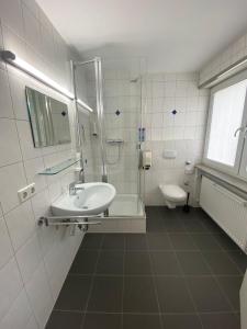a bathroom with a sink and a shower and a toilet at AWM Korntal in Korntal-Münchingen