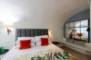 a bedroom with a large bed with red pillows at Loft Corso Cavour in Perugia
