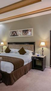 a hotel room with two beds and a table with lamps at Levant Hotel in Najran