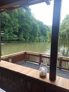 a porch with a view of a river at Salaš Mlýn in Velehrad