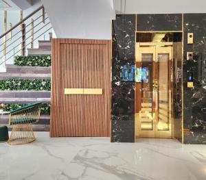un vestíbulo con una puerta de madera y escaleras en The Saina International - New Delhi - Paharganj, en Nueva Delhi