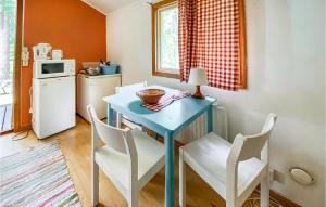 cocina con mesa azul y sillas blancas en Cozy Home In Ljungby With Kitchen en Ljungby