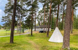 a white tent in the grass next to trees at Cozy Home In Ljungby With Kitchen in Ljungby