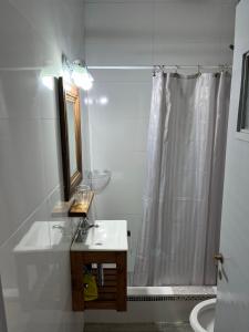 a bathroom with a sink and a shower with a mirror at Junto Al Mar Y Centro De Santa Clara, Dos Casas in Santa Clara del Mar