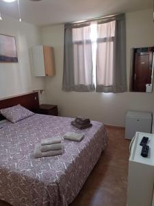 ein Schlafzimmer mit einem Bett mit zwei Handtüchern darauf in der Unterkunft Kiki vivienda Bed & breakfast in San Isidro