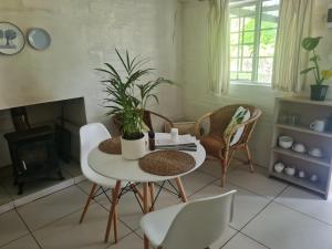 Oak Lane Cottages في إلغين: غرفة معيشة مع طاولة وكراسي ومدفأة