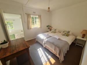 1 dormitorio con cama, mesa y ventana en Oak Lane Cottages, en Elgin