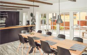 a kitchen and dining room with a wooden table and chairs at Matildes Hus in Skagen